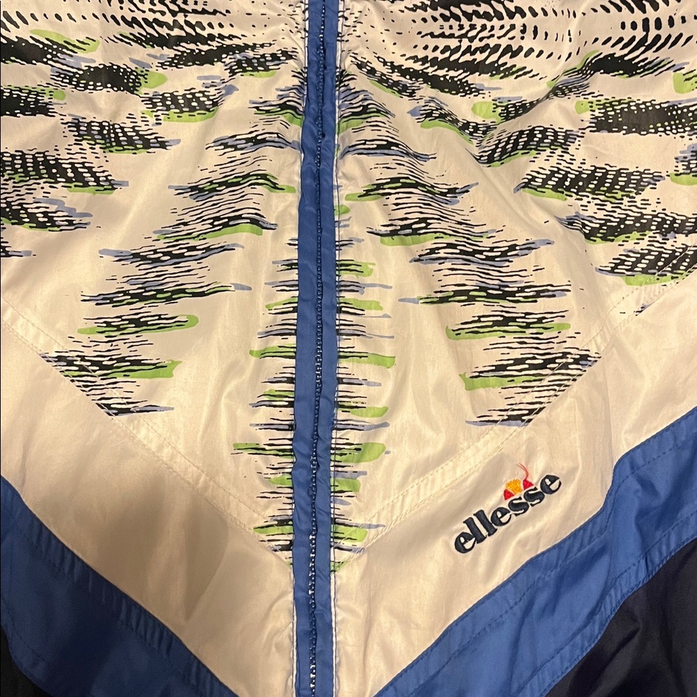 Ellesse Windbreaker
Blue and White Shell Jacket with Lime Graphic Accents